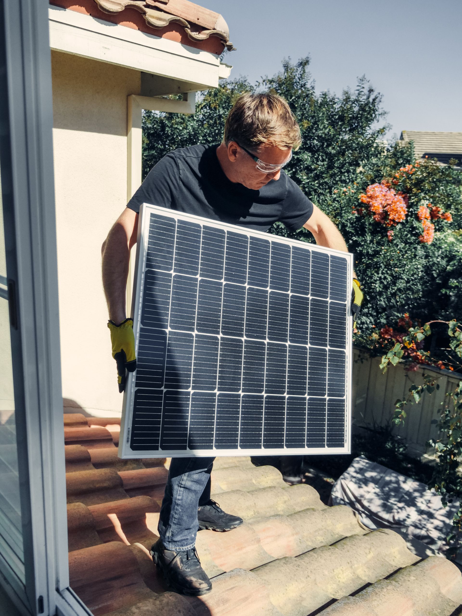 Monteur plaatst zonnepaneel bij een woning